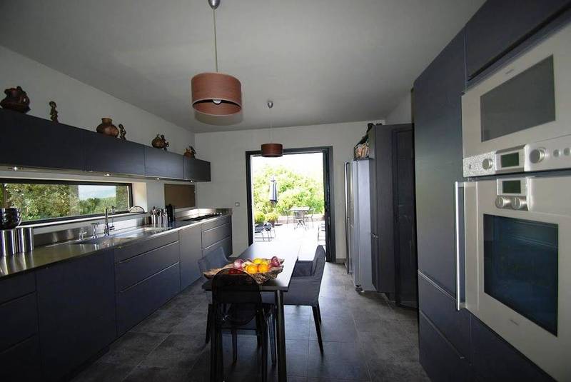 Cuisine moderne équipée avec terrasse et vue panoramique dans cette maison d'architecte à vendre à Menerbes