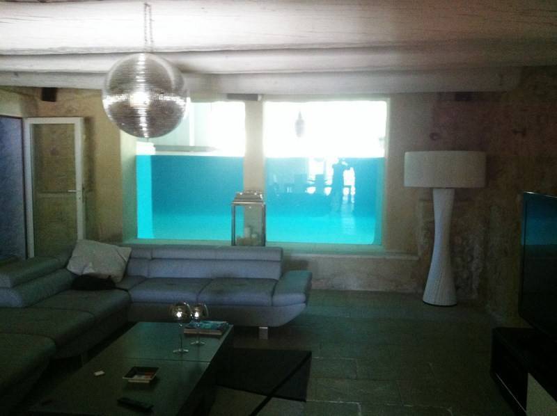 salon avec paroi de verre donnant sur la piscine dans cette propriété de prestige à vendre en Avignon