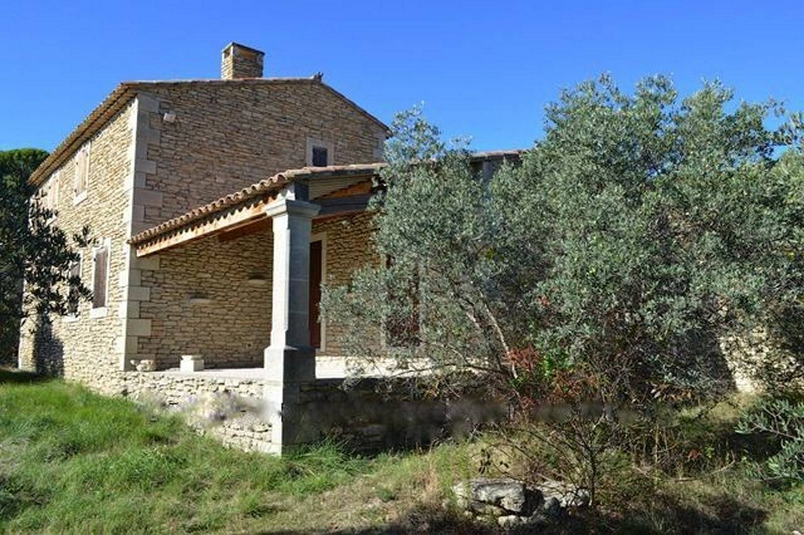 Maison en pierre sèche à vendre à Gordes avec une vue panoramique et terrain d'oliviers