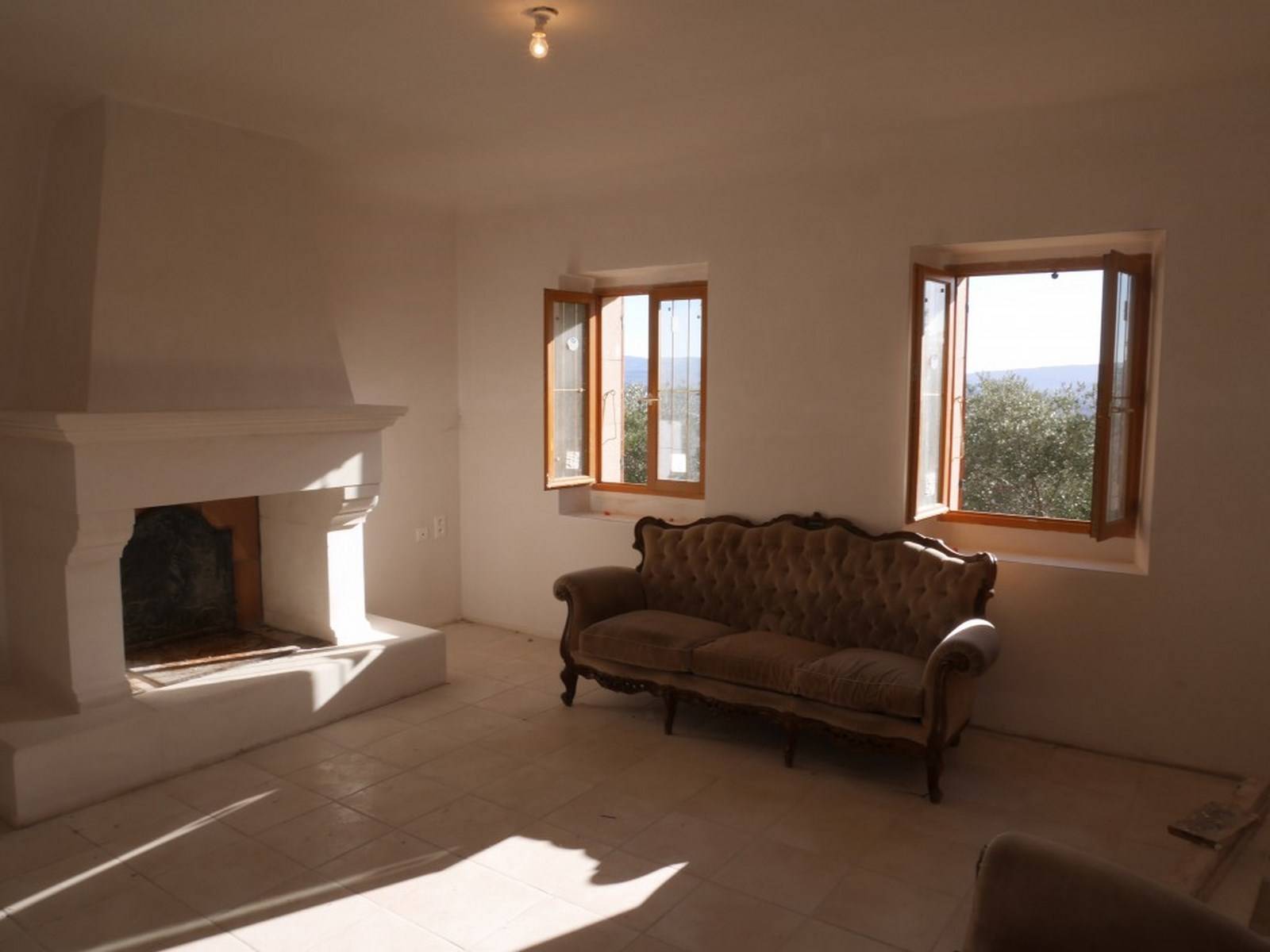 Maison en pierre sèche à vendre à Gordes avec une vue panoramique et terrain d'oliviers