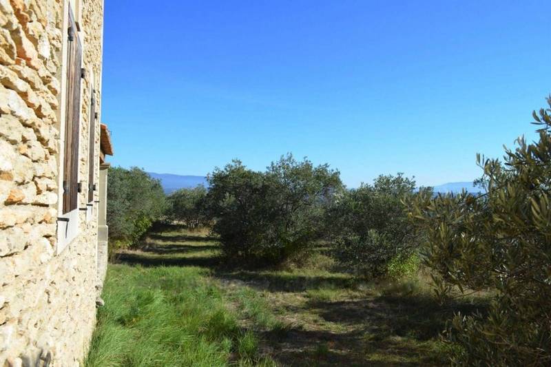 Maison en pierre sèche à vendre à Gordes avec une vue panoramique et terrain d'oliviers